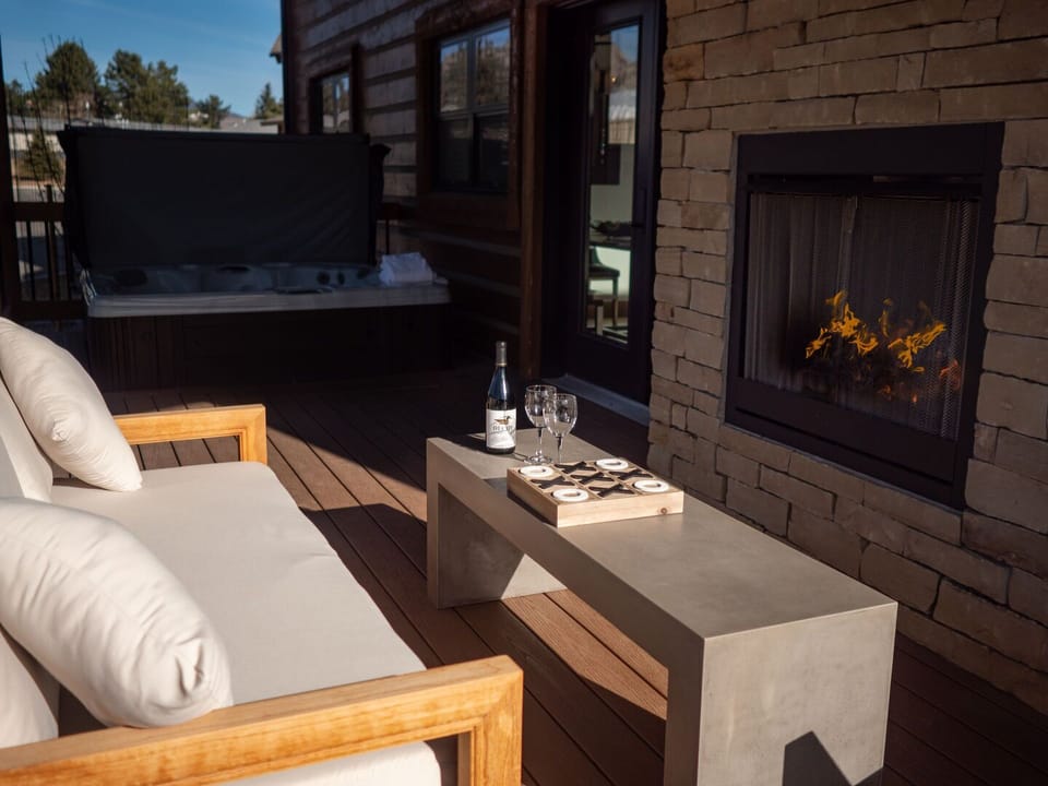 Outdoor patio with fireplace and hot tub