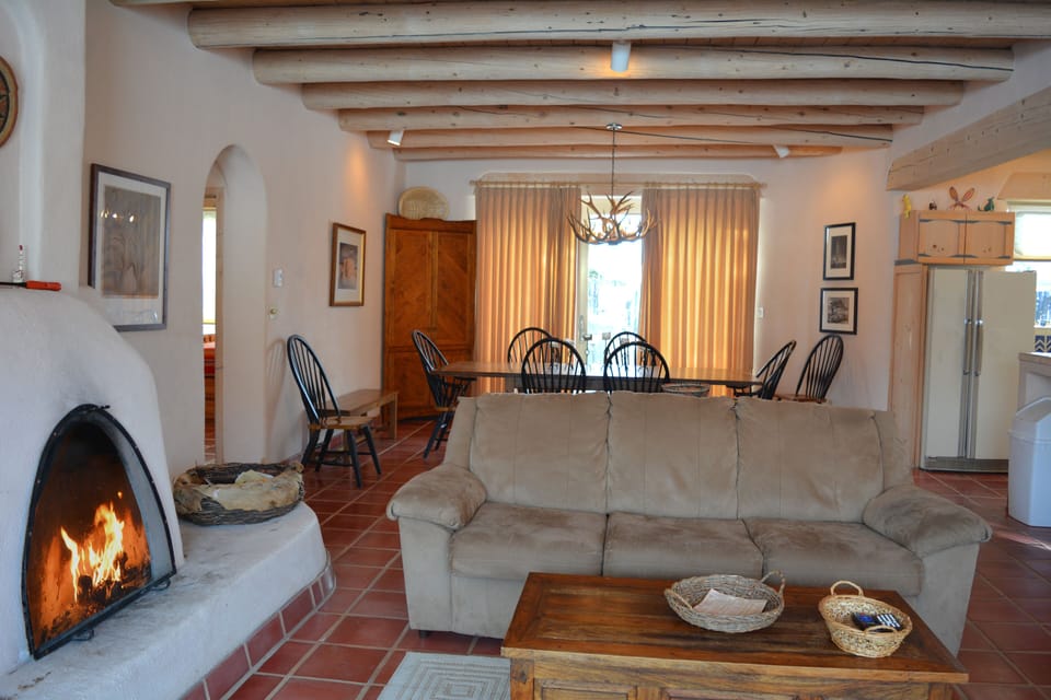 Fireplace views to dining table and entry hall on left to both guest bedrooms