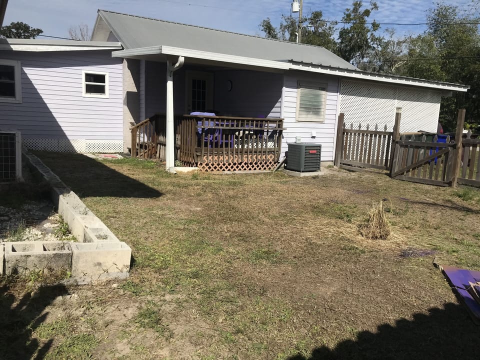 Fenced in yard with deck under roof

