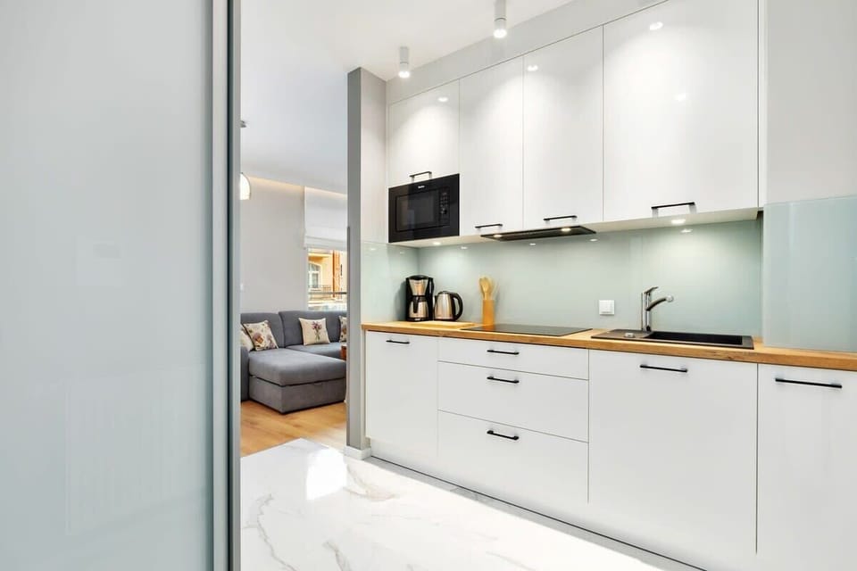  The kitchen includes a stovetop, oven, and ample counter space. A modern dining table sits nearby, perfect for enjoying meals.