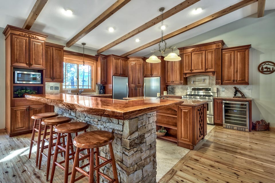 Cook in this stunning gourmet kitchen featuring rich wood cabinetry, granite countertops, and a spacious stone island perfect for gathering.