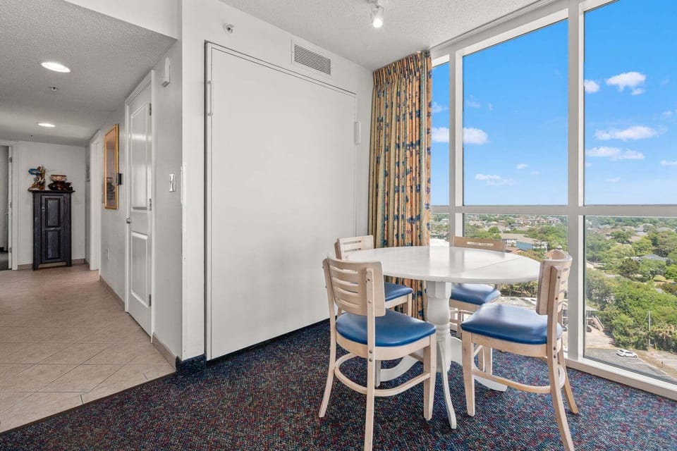 Round dining table for four beside bright windows at Avista Ocean Resort 1514, a 1-bedroom Ocean Drive condo