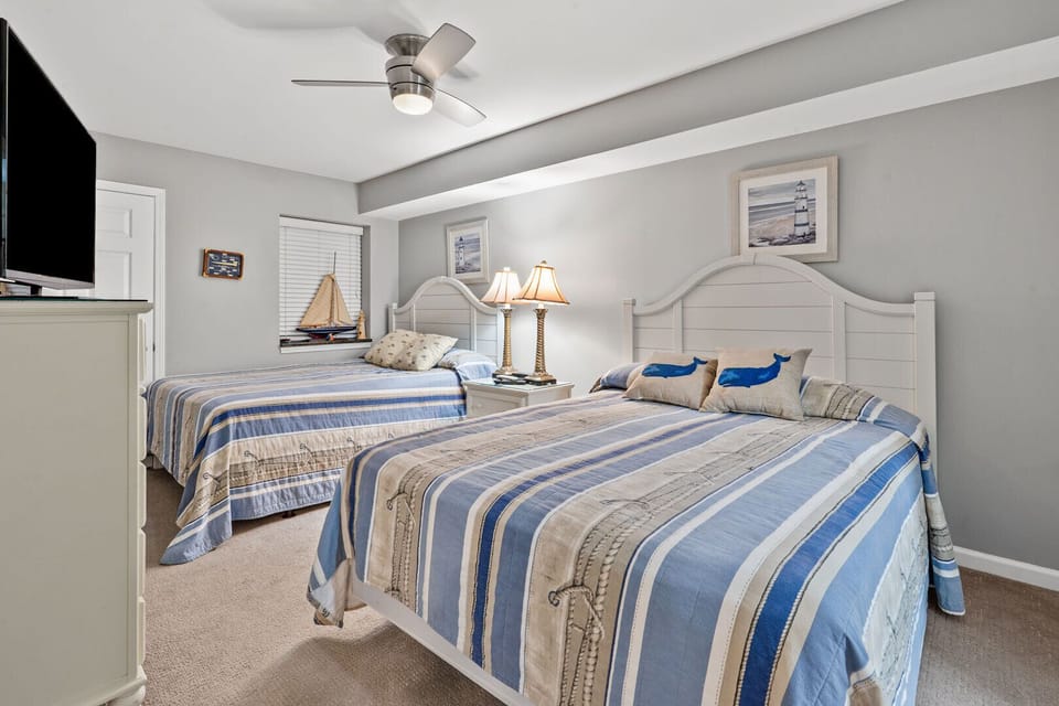 Two beds with striped nautical bedding in this 3-bedroom Crescent Beach condo rental, South Shore Villas Penthouse 2