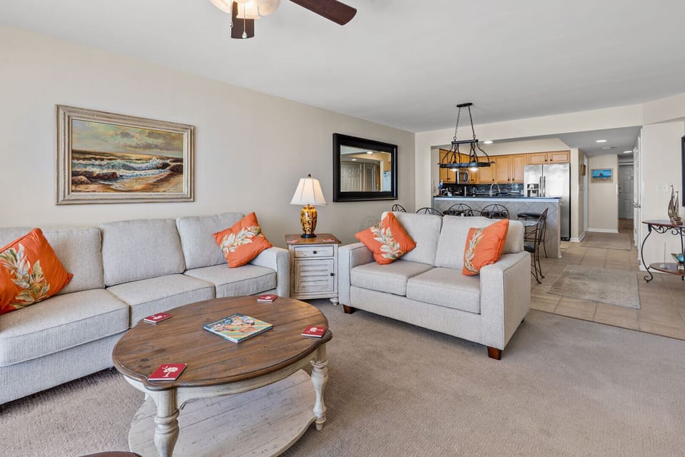 Living area with orange accents and the kitchen beyond at South Shore Villas Penthouse 2, Crescent Beach