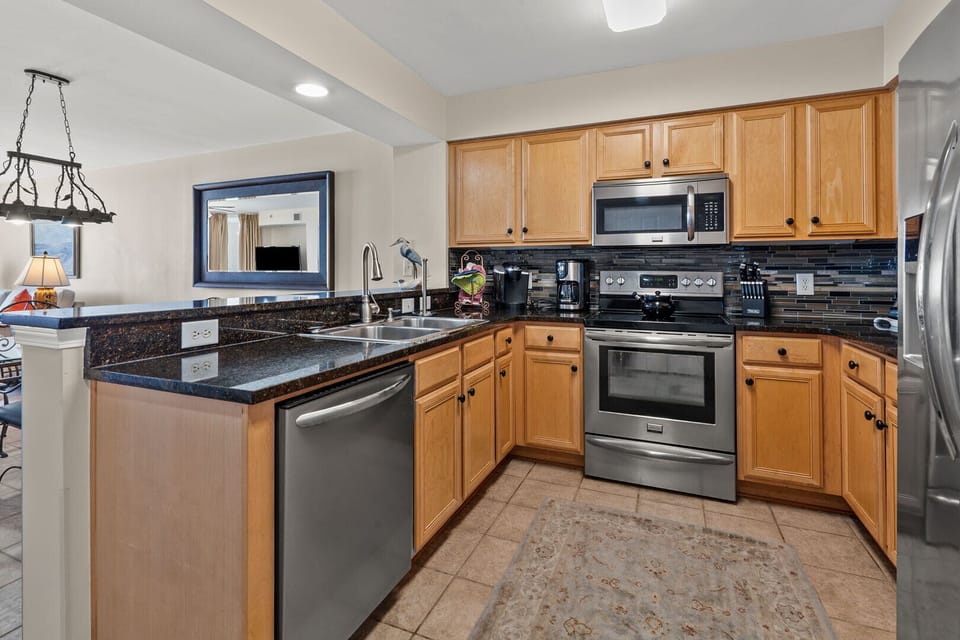 Kitchen with dark counters, a double sink and full appliances at South Shore Villas Penthouse 2, Crescent Beach