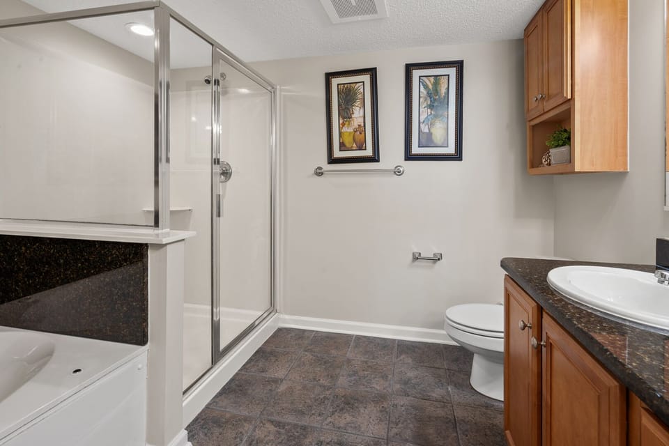 Bathroom with a glass shower, tub and grab bars at Crescent Shores 1303, a Crescent Beach vacation rental