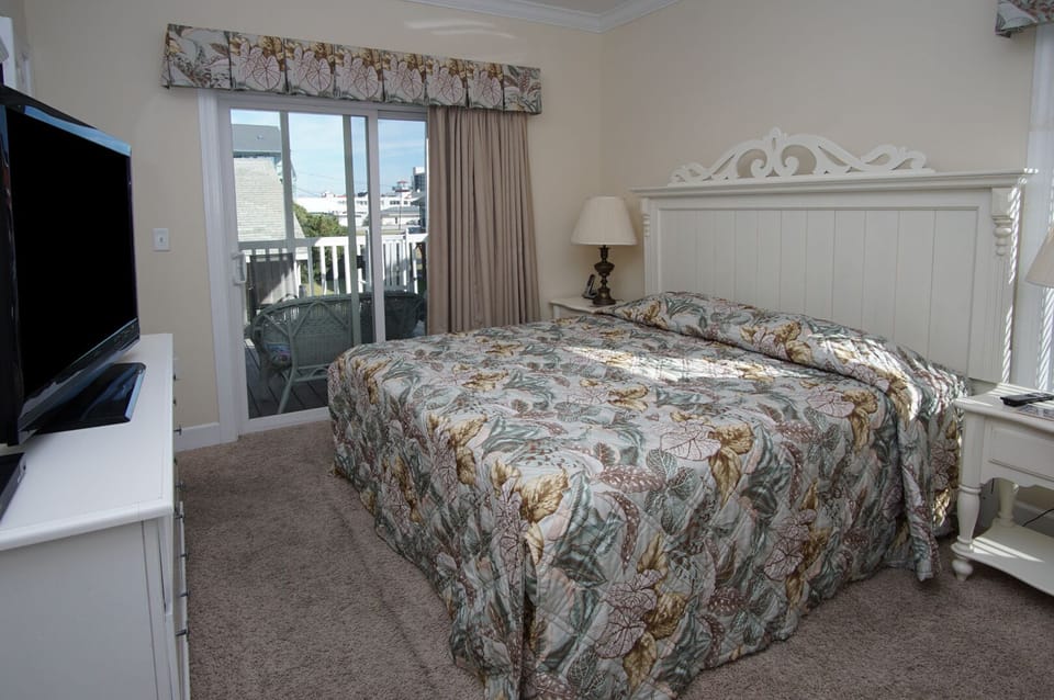 Bedroom with sliding doors opening onto the balcony at Pool House, a Cherry Grove vacation rental