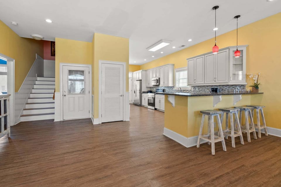 Kitchen bar with stools and red pendant lights at Another Day in Paradise, a Cherry Grove vacation rental