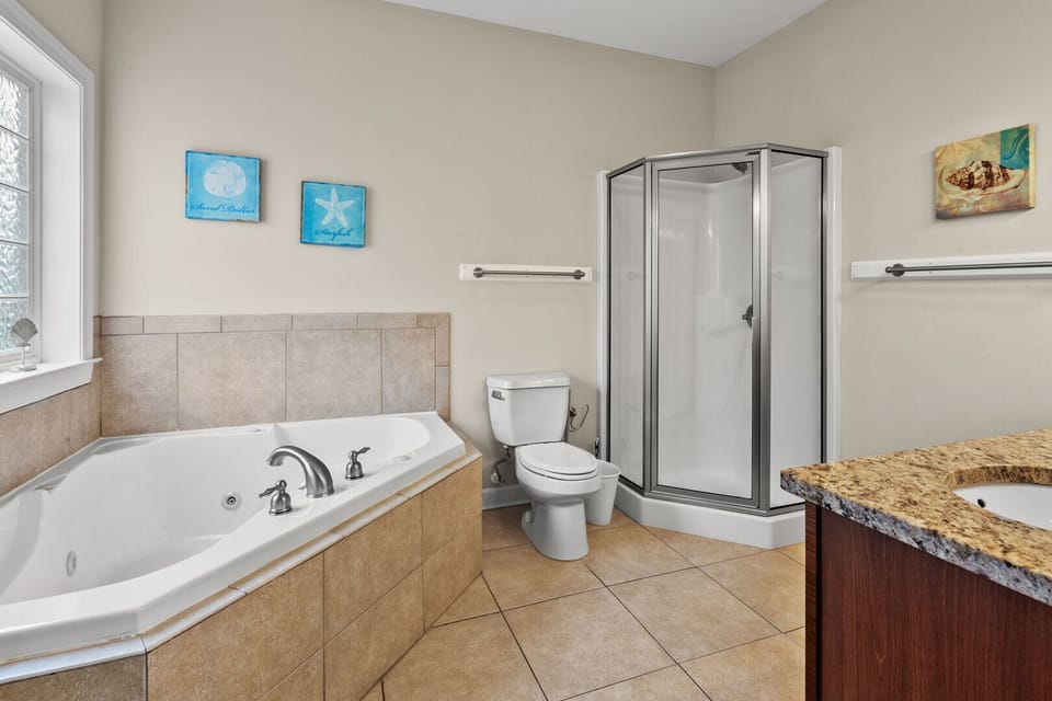 Bathroom with a corner tub, walk-in shower and long vanity at Amy's Oasis, a 5-bedroom Windy Hill rental