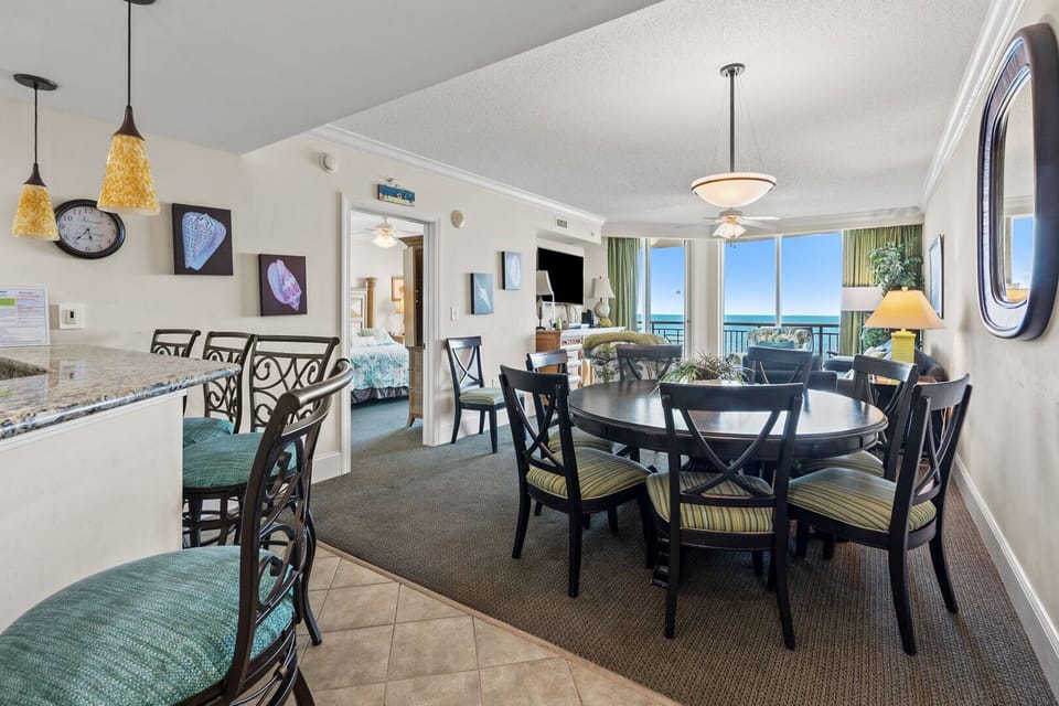 Dining seating beside wide ocean-view windows at Mar Vista Grande 712, a 3-bedroom Ocean Drive condo rental
