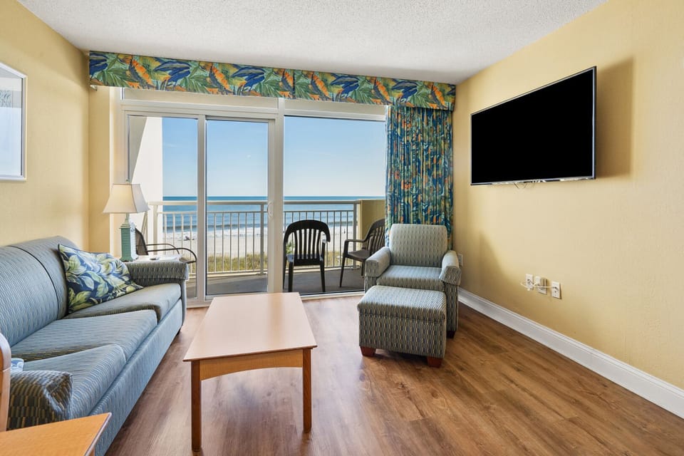Sectional sofa facing the balcony doors and ocean at Bay Watch I 308, a 2-bedroom Crescent Beach condo rental