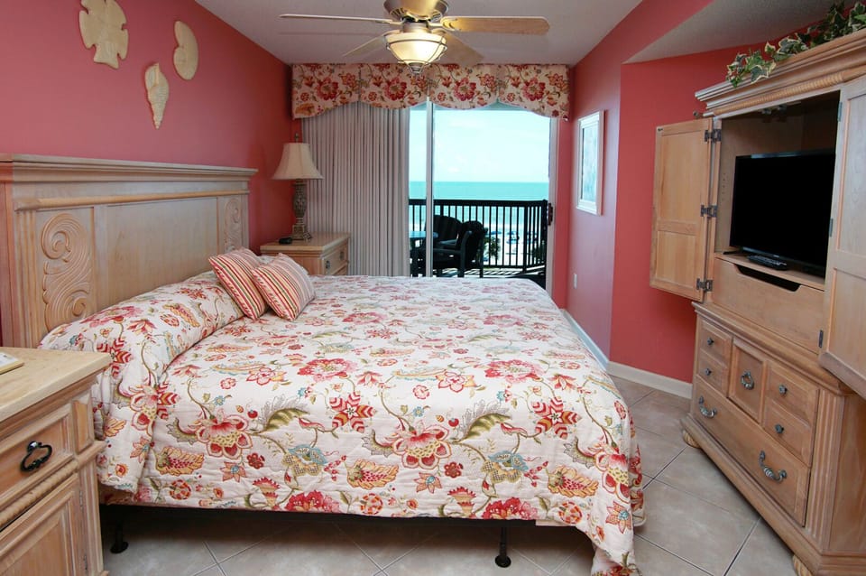 Bedroom with a ceiling fan and sliding door to the ocean-view balcony at Ashworth 305, Ocean Drive
