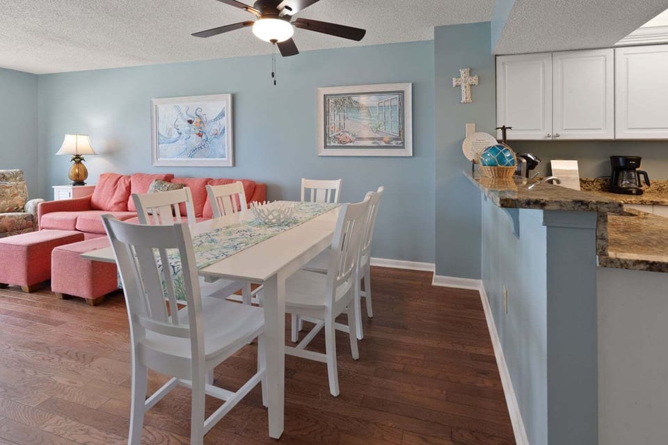 Dining table for six sits between kitchen and living area at Windemere 703, a 3-bedroom Ocean Drive condo