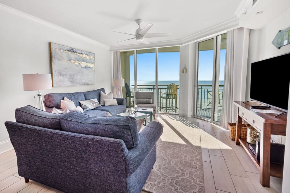 Sectional seating and coastal art beside the balcony doors at Mar Vista Grande 505, an Ocean Drive vacation rental