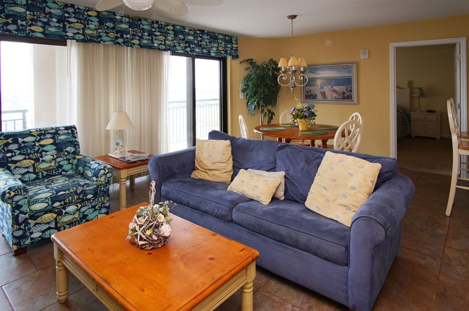Living and dining area with a fish-print armchair at Beachwalk Villas 701 in Cherry Grove, North Myrtle Beach