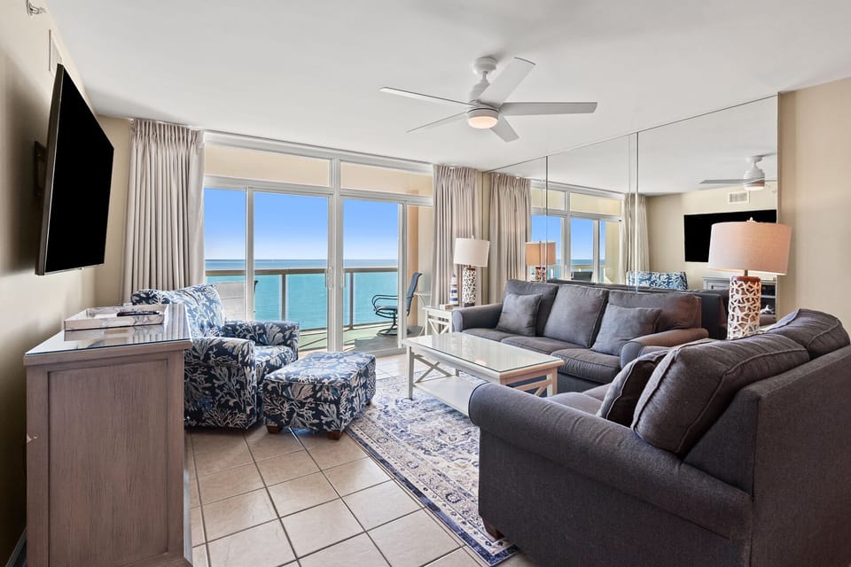 Ceiling fan, TV and sliding doors frame the ocean view in the living area at Laguna Keyes 1104, Cherry Grove