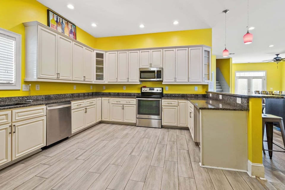 Kitchen with white cabinetry and an island with bar stools at A Perfect Escape in Cherry Grove