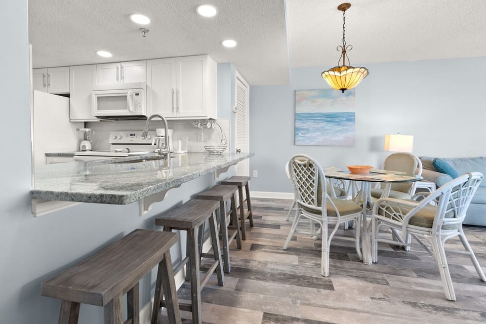 Bar counter with stools beside the dining table at Shalimar 1B, a 2-bedroom condo in Cherry Grove
