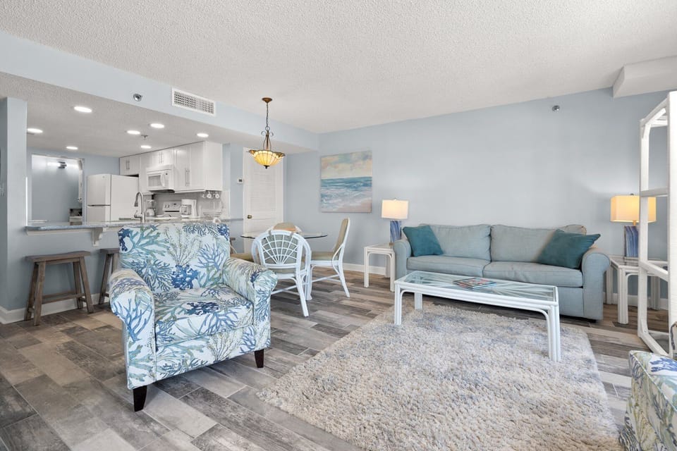Open living, dining and kitchen space in blue and white at Shalimar 1B, a Cherry Grove condo rental