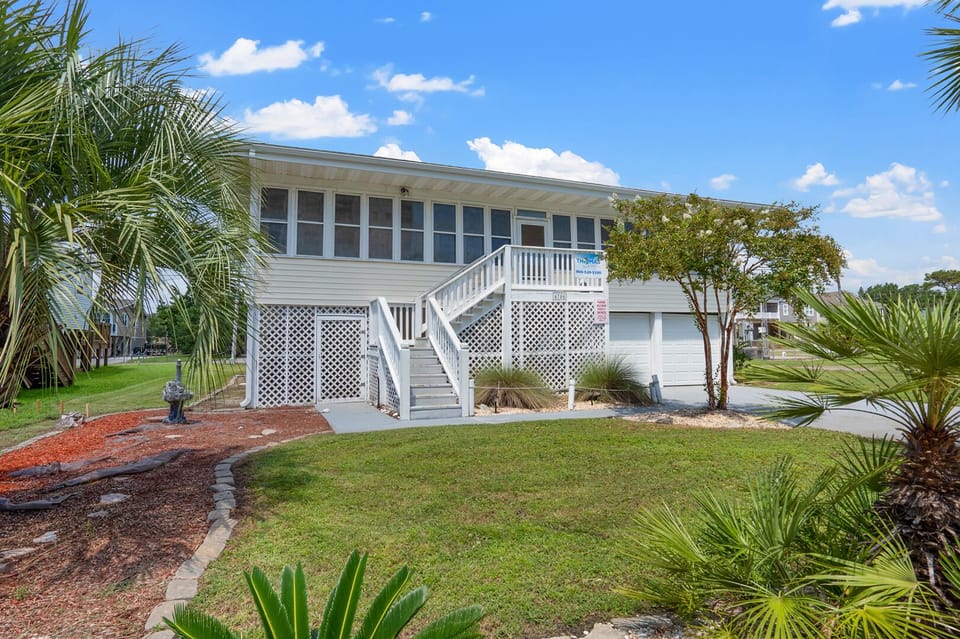 Front exterior with palm trees at Boathouse, a 4-bedroom Windy Hill vacation rental in North Myrtle Beach