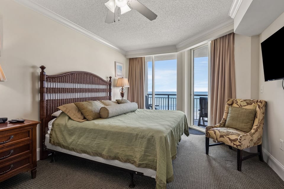 Bedroom with balcony doors and green bedding at Mar Vista Grande 713, a 3-bedroom Ocean Drive condo rental