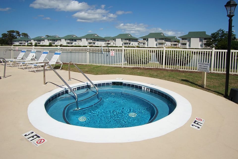 Hot tub set beside the pool deck at Tilghman Lakes N4, a 2-bedroom condo in Tilghman Beach, North Myrtle Beach