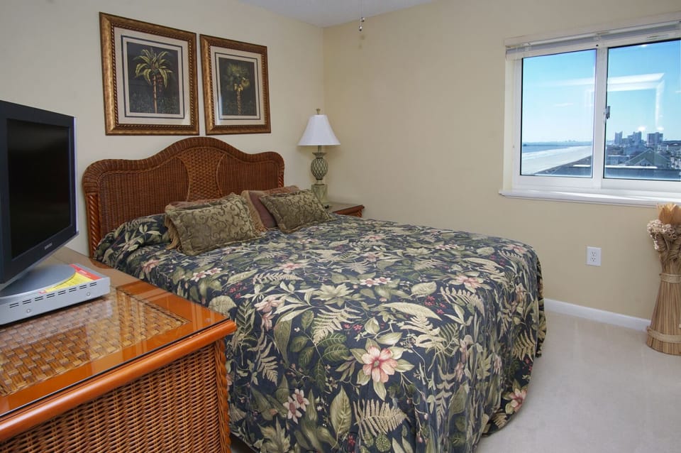 Bedroom with floral bedding and a neighborhood view at Paradise Pointe 6A in Cherry Grove