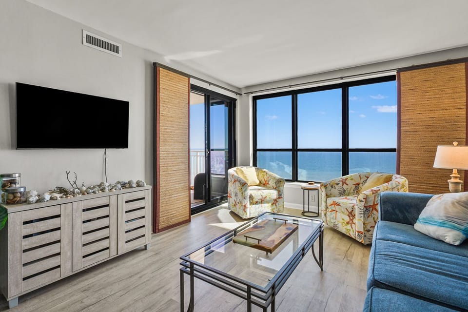 Sliding doors open from the living area to the balcony at Windemere 902, an Ocean Drive vacation rental