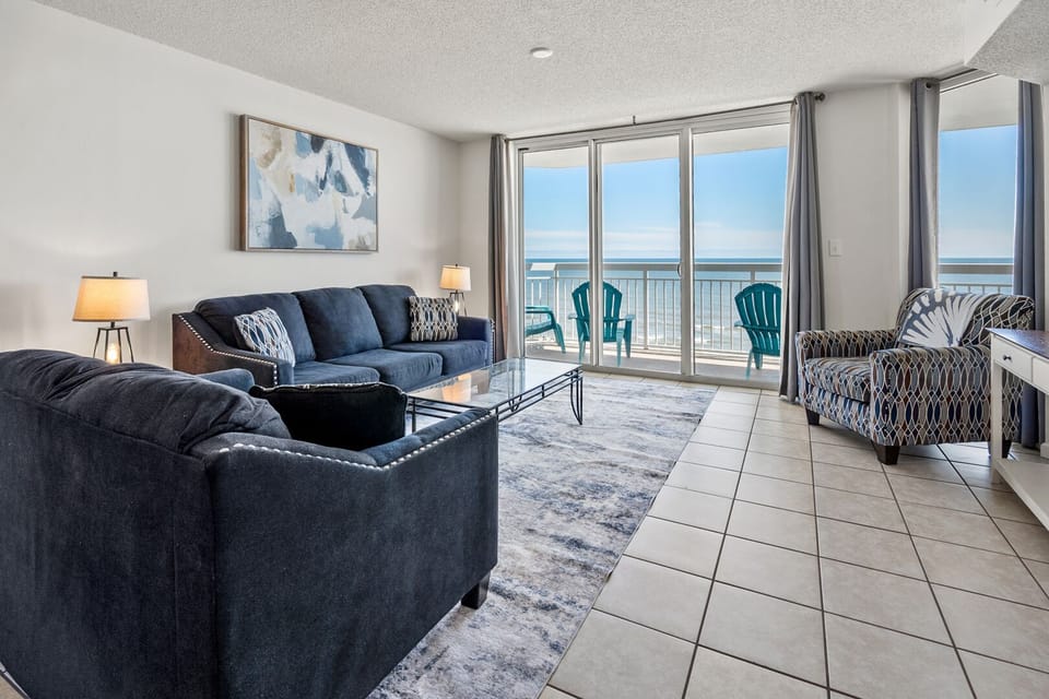 Sectional seating and sliding doors framing the ocean at Crescent Shores 706 in Crescent Beach