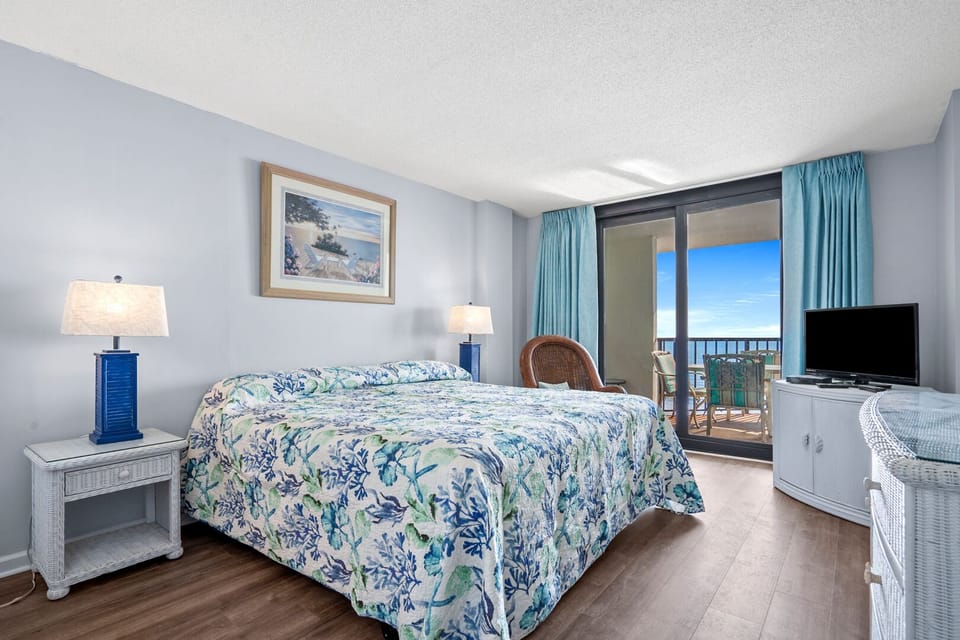 Bedroom opening to the ocean-view balcony at Crescent Sands of Crescent Beach J6, a 3-bedroom condo rental