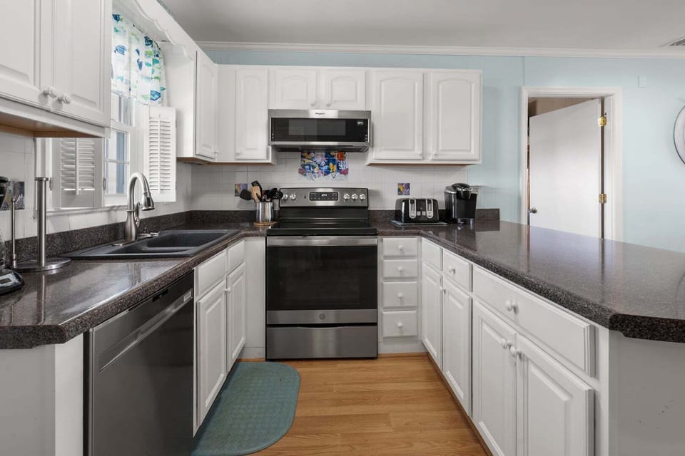 Cooking range, large sink and dark counters in the kitchen at Anchor in the Waves in Cherry Grove
