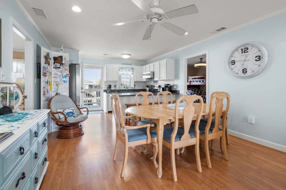 Dining table for six beside the kitchen with white cabinetry at Anchor in the Waves, Cherry Grove
