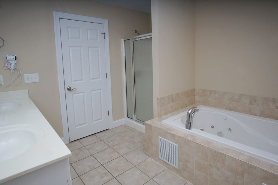 Bathroom with a wide vanity, walk-in shower and soaking tub at West Winds II, a 5-bedroom Crescent Beach rental