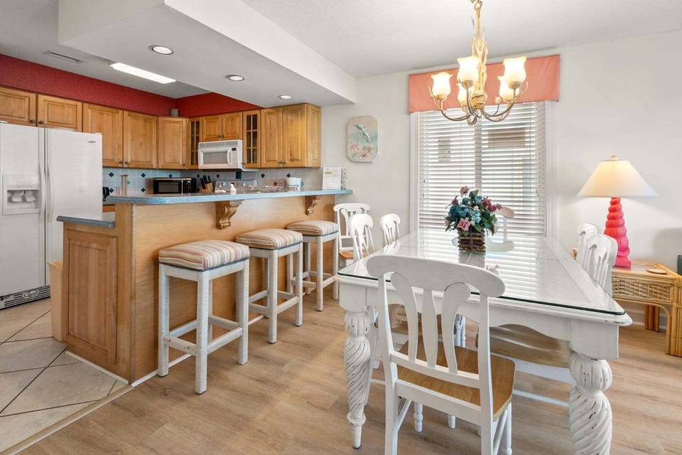 Breakfast bar with stools beside the dining table at Surf Villas II C1, a 3-bedroom Ocean Drive condo rental