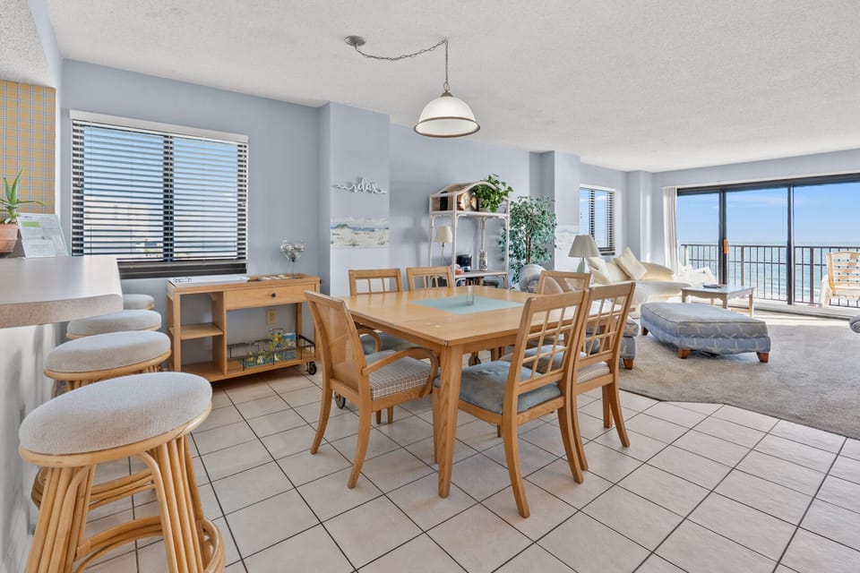 Dining space with balcony doors and an ocean view at Springs Towers 401, a 3-bedroom Cherry Grove condo