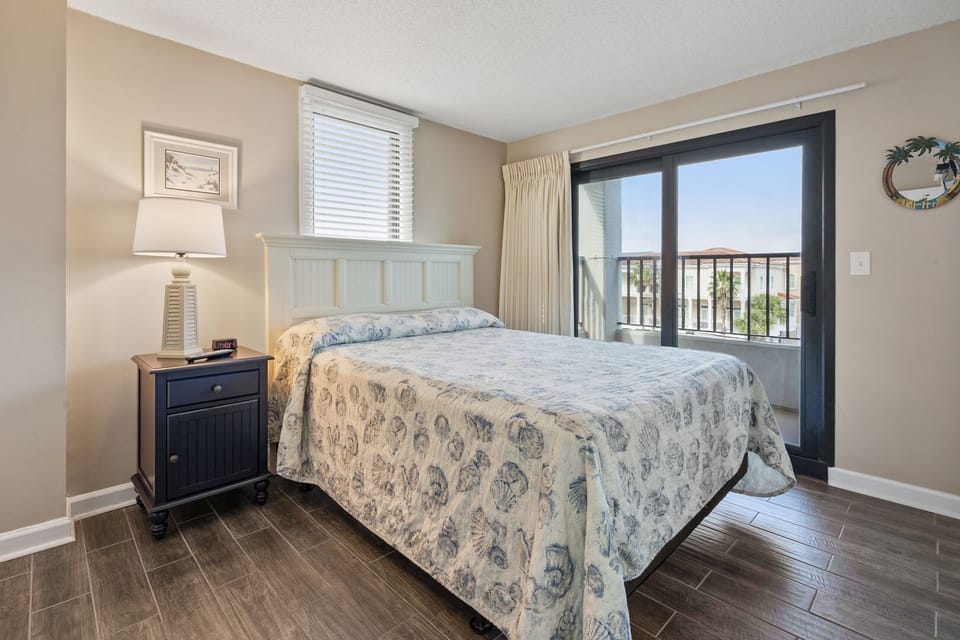 Sliding doors lead from this bedroom to the balcony at Sea Marsh 304, Cherry Grove vacation rental