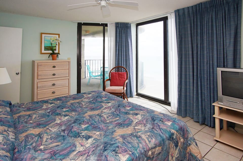 Bedroom with balcony doors and a TV at Sea Castle 6D in Crescent Beach, North Myrtle Beach