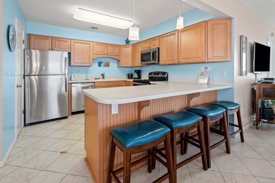 Kitchen island with bar stools under blue walls at Sand Trap Villas C1, Cherry Grove, North Myrtle Beach