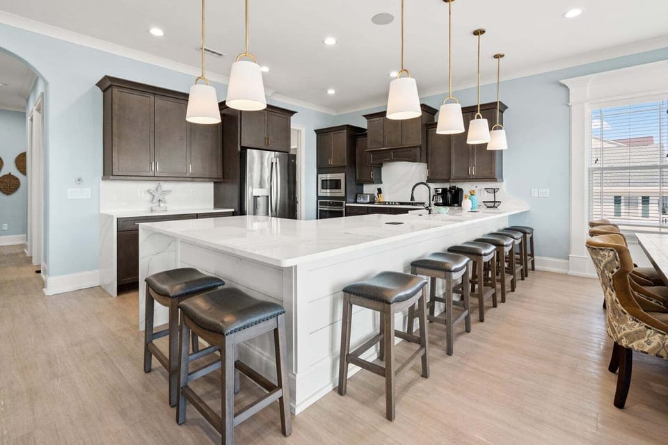 Kitchen island with bar stools and dark cabinetry at A New Beginning in Cherry Grove