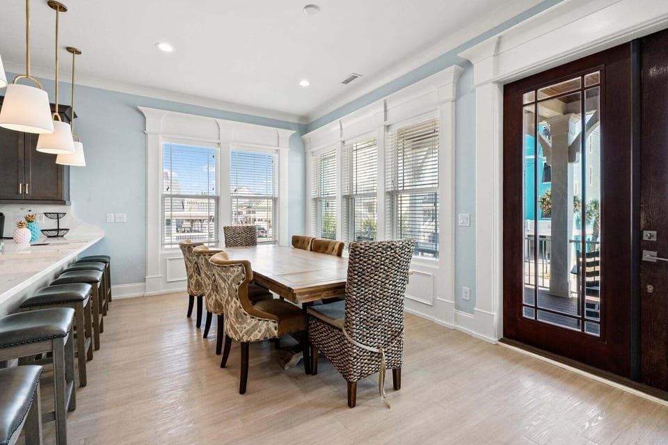 Dining table for the whole group beside tall glass doors at A New Beginning in North Myrtle Beach