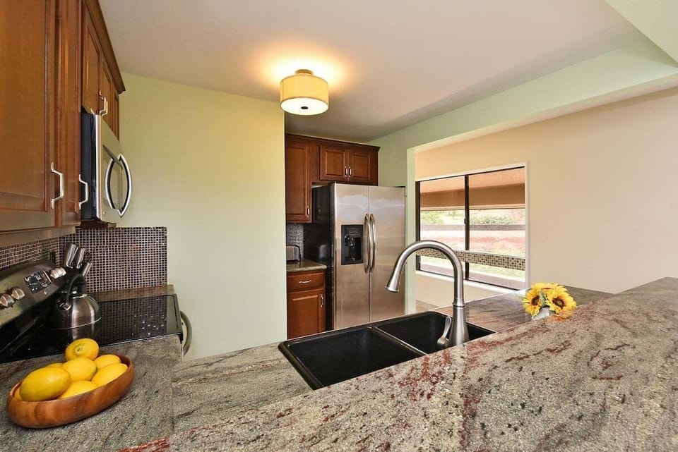 Bright and contemporary kitchen design with ample counter space and stainless steel appliances for convenience
