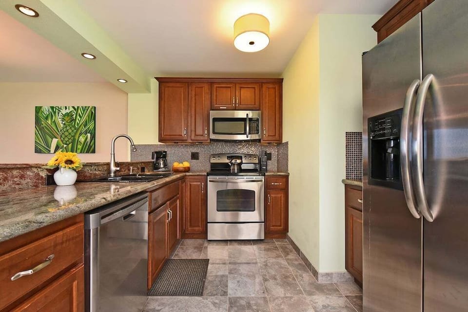 Modern kitchen featuring stainless steel appliances, granite countertops, and rich wood cabinetry for a stylish and functional space