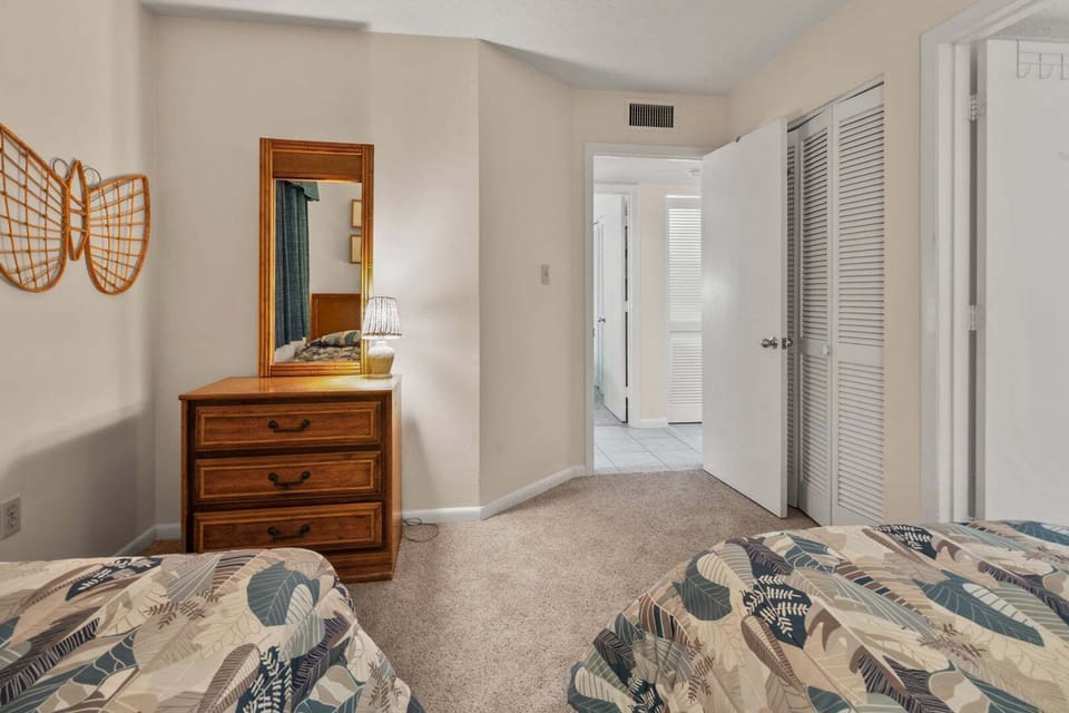 Beds side by side with a dresser and mirror at Shoreham Towers II 2D in Crescent Beach, North Myrtle Beach