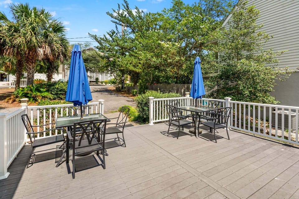 Patio tables under blue umbrellas at Blue Atlantic, a 4-bedroom Ocean Drive vacation rental