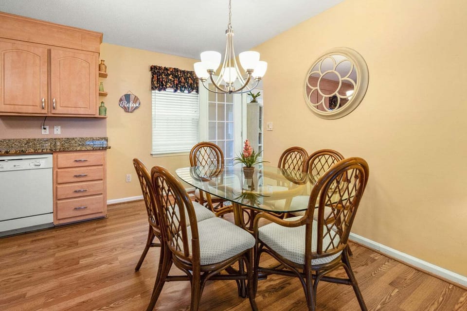 Glass-top dining table beside the kitchen at Blue Atlantic, a 4-bedroom Ocean Drive vacation rental