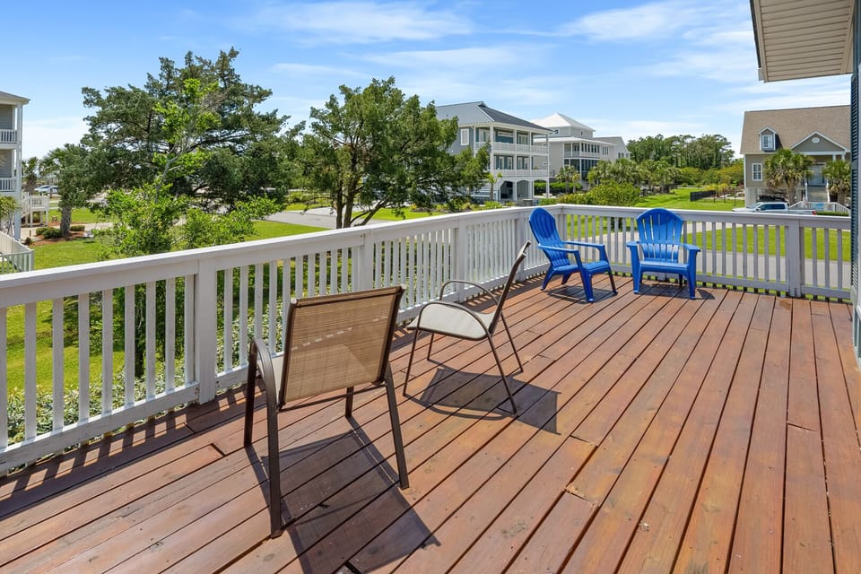 Deck with blue Adirondack chairs and lounge seating at Lumley House, a 4-bedroom Tilghman Beach vacation rental