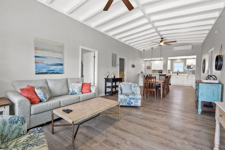 Open-concept living and dining space with a ceiling fan and the kitchen beyond at Pelican's Perch, Cherry Grove
