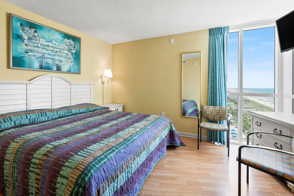 Windows and seating fill a bedroom with ocean views at Avista Ocean Resort 801, Ocean Drive