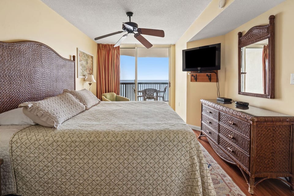 Bedroom with a wall-mounted TV and sliding door to the ocean-view balcony at Ashworth 1403, Ocean Drive