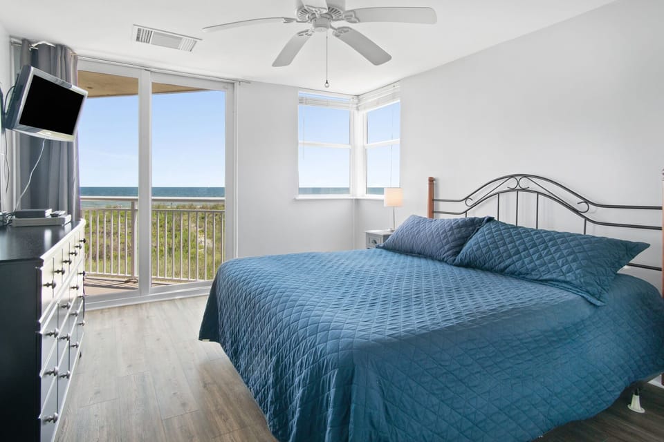 Bedroom with balcony doors and an ocean view at Hyperion Towers 102, a 2-bedroom Cherry Grove condo